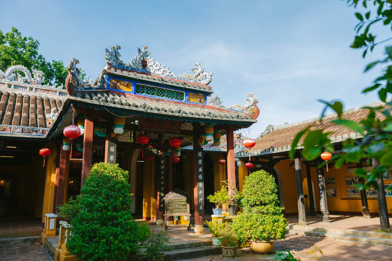 Scenic view of a Vietnamese temple facade adorned with red lanterns and lush greenery.